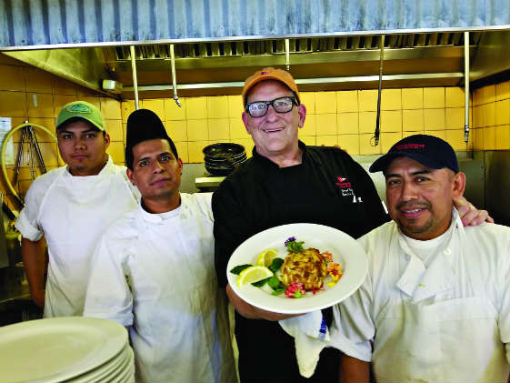 Boatyard Bar & Grill chef George Betz and staff show off a crabcake. Photo by Craig Ligibel