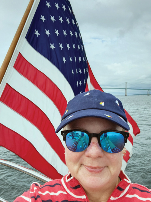 woman on a sailboat with a flag in the background