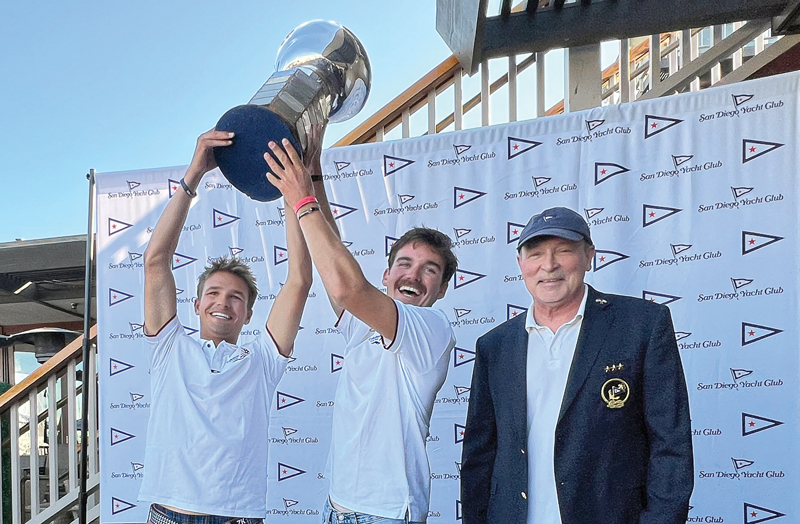 Justin Callahan and Trevor Davis raise a trophy above their heads. Photo by SCIRA/Mark Albertazzi/ San Diego Yacht Club