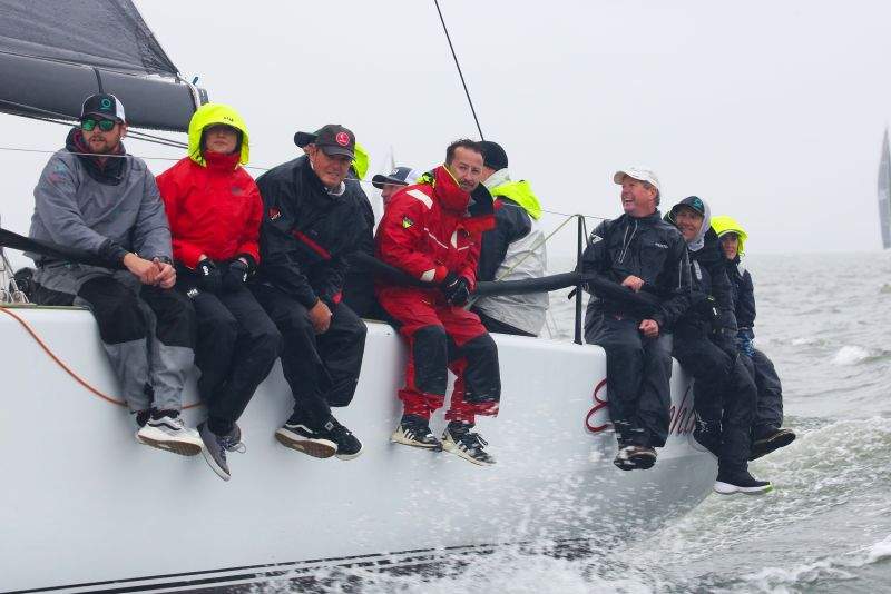 sailors wearing foul weather gear on a racing sailboat.