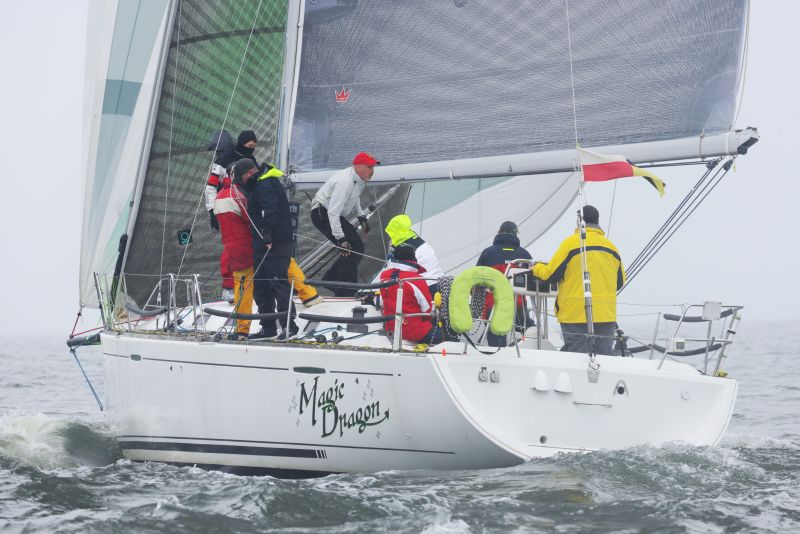 a sailboat crew racing on a rainy day.
