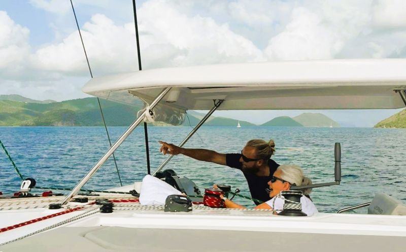Captain and sailor on charter at helm station