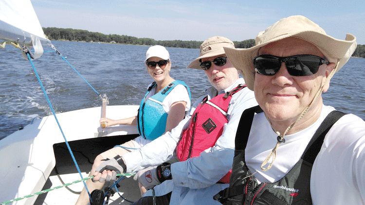 Patty, at the tiller, and Bill Allman, front, with their West River SC friend, Terry,