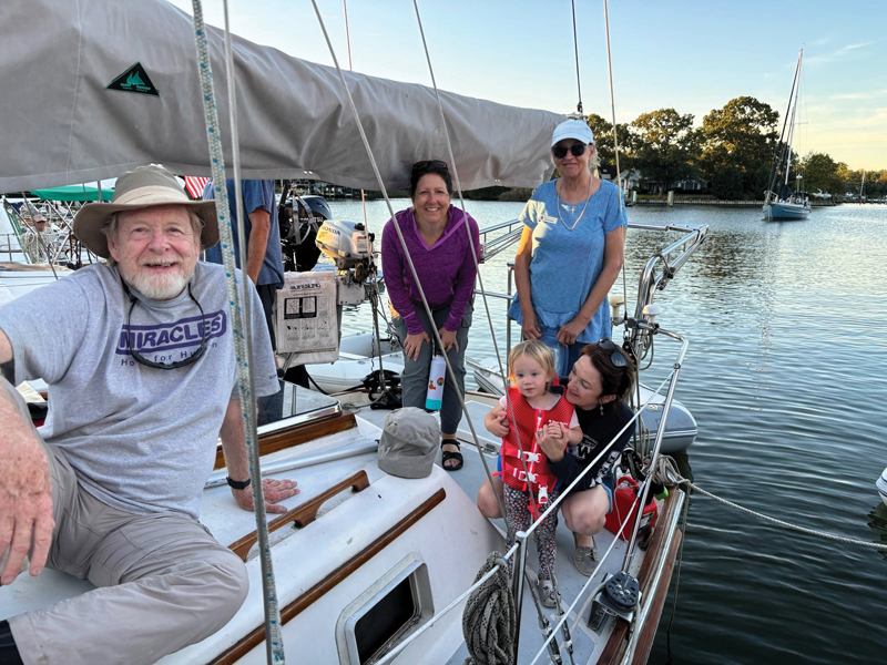 adults and a child on the deck of a Bristol sailboat at anchor