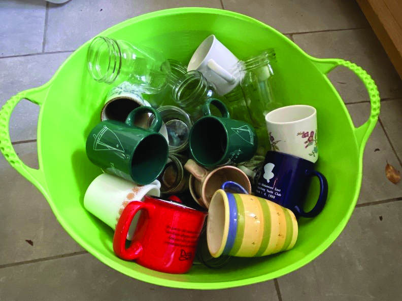 a green bowl filled with drinking cups
