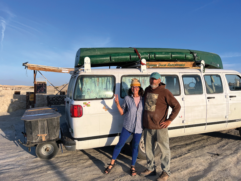 Sailboat cruising and camping on the Chesapeake Bay campers pose with a boat on the roof of their van in the background