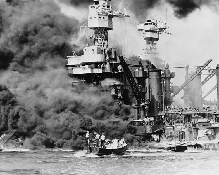  A small boat rescues a seaman from the 31,800 ton USS West Virginia (BB-48), which is burning in the foreground. Smoke rolling out amidships shows where the most extensive damage occurred. Note the two men in the superstructure. The USS Tennessee (BB-43)