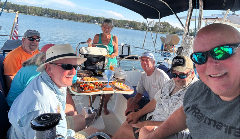 HSA-1 members gather in the cockpit during a summer cruise Cruising club members gather in the cockpit of a sailboat