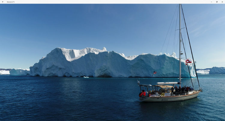 S/V Celebrate sailing in front of an iceberg in Greenland before reaching the NW Passage.