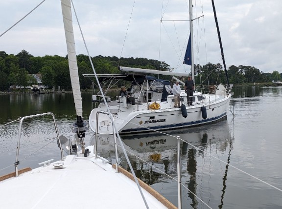 A sailboat and sailors on the water practicing maneuvers