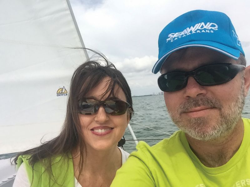 A man and a woman smiling on a sailboat
