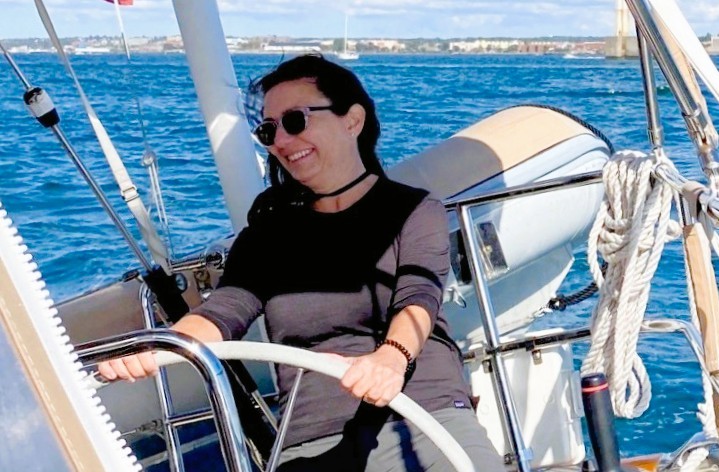 A woman at the helm sailing a boat