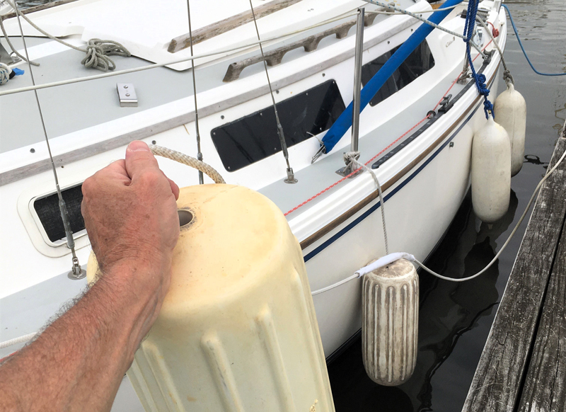 sailboat at dock with fenders for hurricane preparation fenders placed on sailboat at dock for hurricane preparation