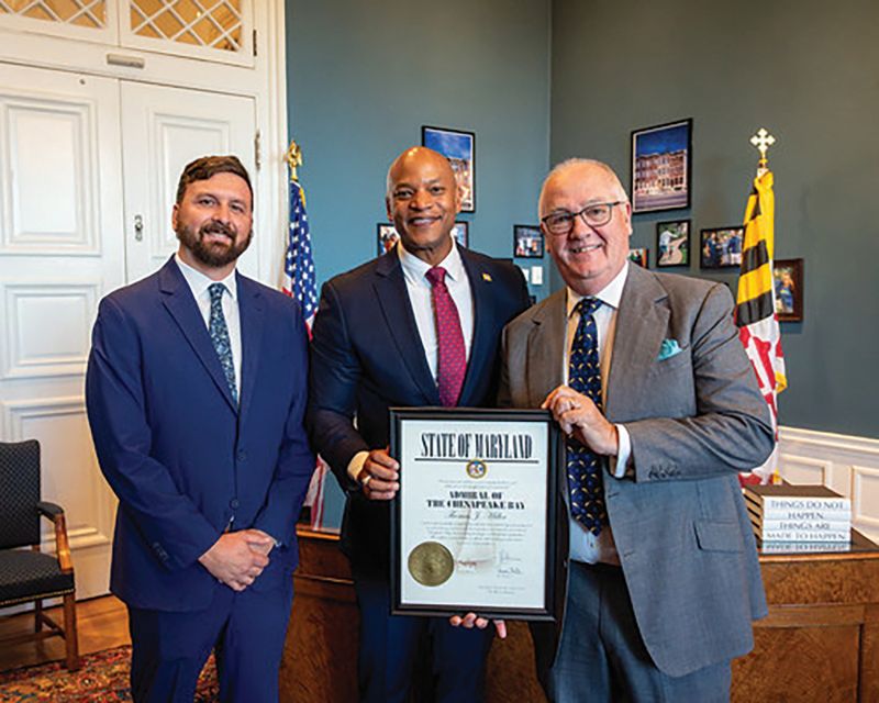 DNR Secretary Josh Kurtz and Maryland Gov. Wes Moore present Thomas Miller with the Admiral of the Chesapeake Bay Award in 2025