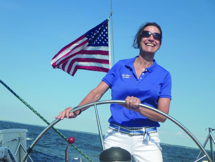 SpinSheet staffer Holly Foster at the wheel aboard the Schooner Woodwind