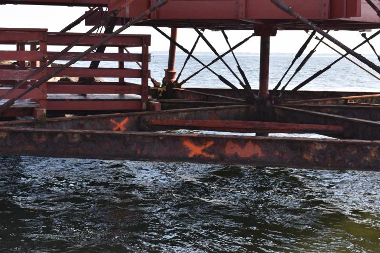 Supporting infrastructure below the Thomas Point Shoal Lighthouse, September 2019.... The badly deteriorated beams marked with an orange X are among those that will be replaced in the current project. Photo by Dave Gendell