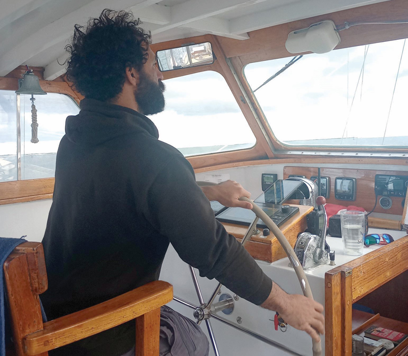 Man steering sailboat