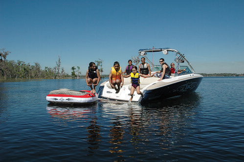 children jumping off boat into water