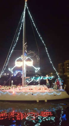 The author's sailboat lit up with wine glasses and other lighted artwork.