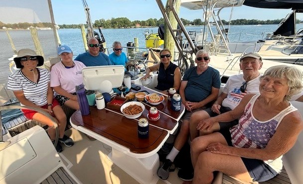 HSA-1 members gather in the cockpit during a summer cruise Cruising club members gather in the cockpit of a sailboat