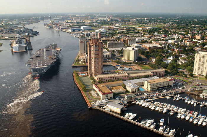 Tug boats guide the USS Harry S. Truman up the Elizabeth River past Portsmouth landmarks. Photo courtesy John L. Beeman/U.S. Navy