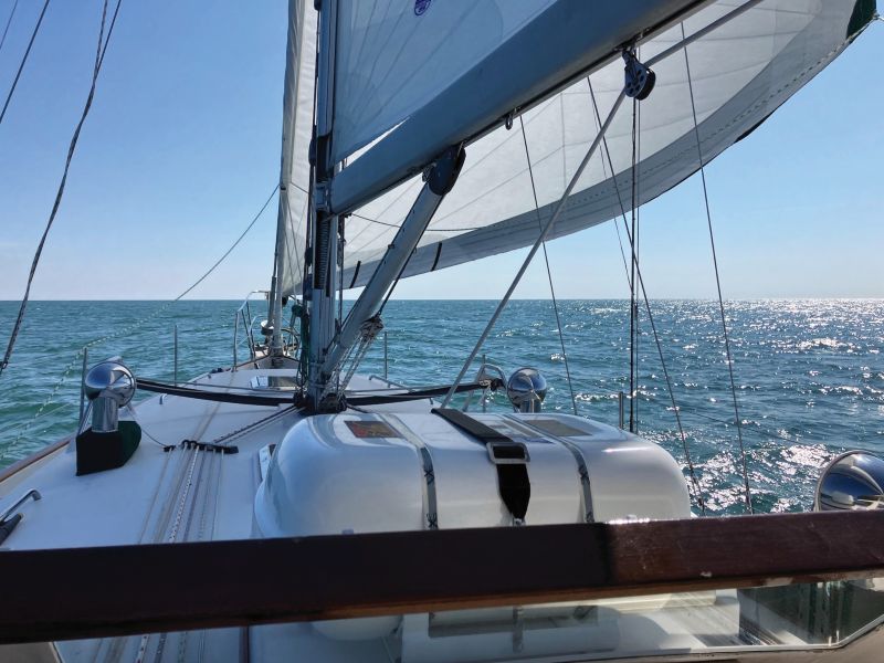 Liferaft mounted on sailboat cabin top, sailing on Atlantic Ocean.