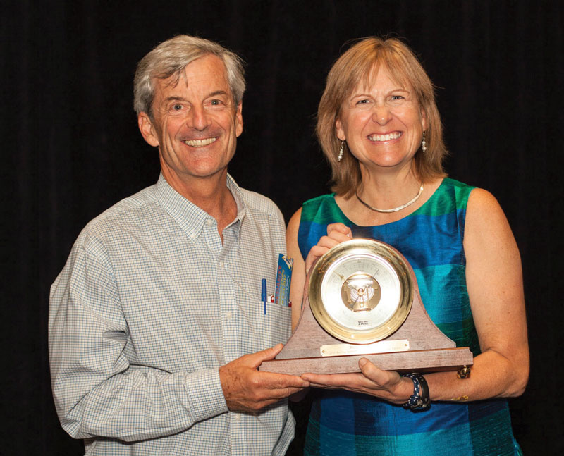 2015 Sailing Industry Distinguished Service Award winner, John Arndt, hands over the award in 2016 to Margaret Podlich. Photo courtesy of Annapolis Boat Shows
