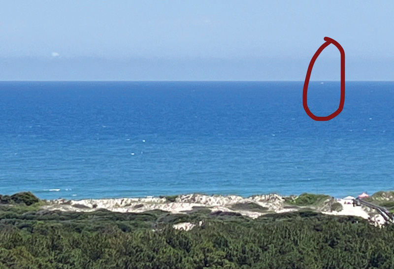 The author's sailboat looked like a speck on the horizon. Sailboat as a speck on the horizon