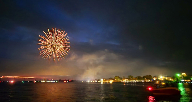 Boating Safety on Independence Day fireworks over the water with a boat in the foreground