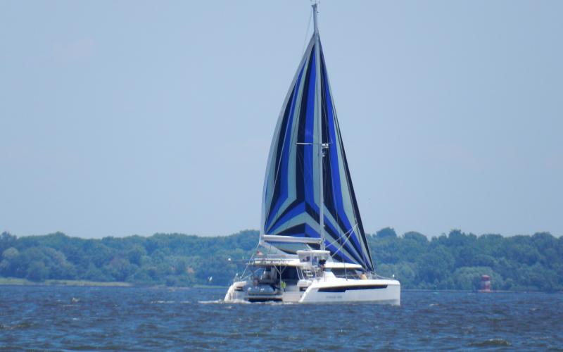 A cruising catamaran with colorful sails