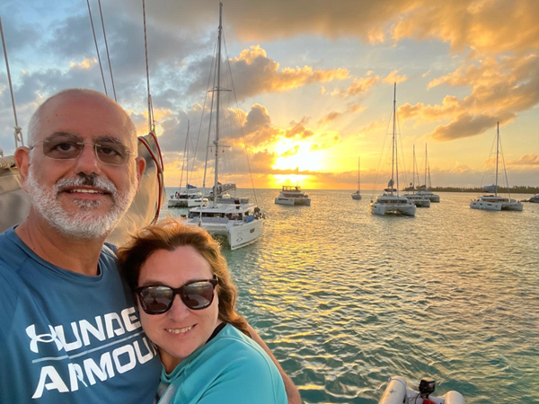 couple at sunset with sailing boats in the background