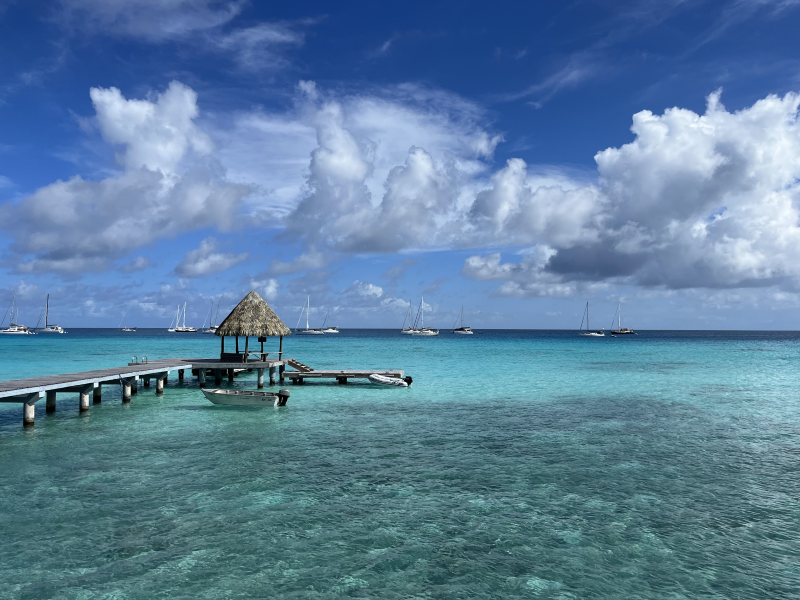 a pier extends into the blue-green waters of the Tuamotus