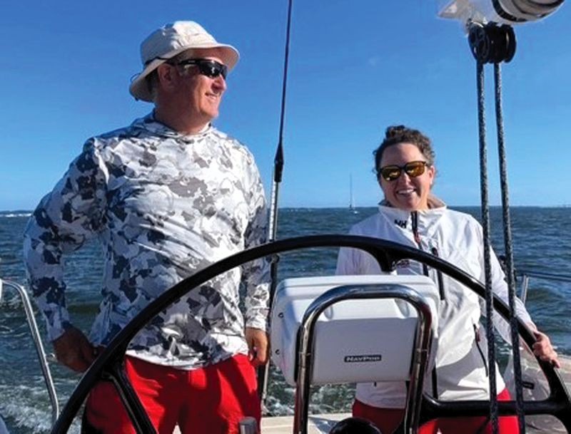 Keith Cole and Michelle Greenhalgh at the helm of Lucky Eights. two sailors at the helm of a sailboat
